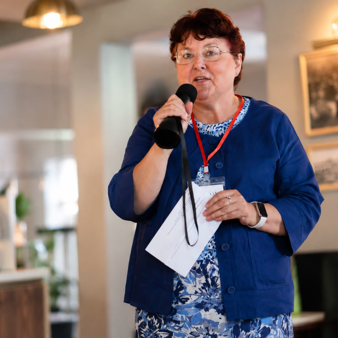 A guest addressing the room with a microphone at a networking event