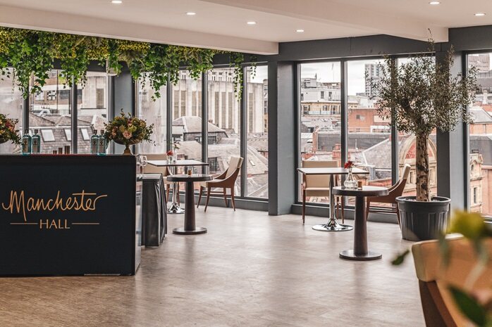 Manchester Hall lounge overlooking the city, with its gold logo displayed at the entrance